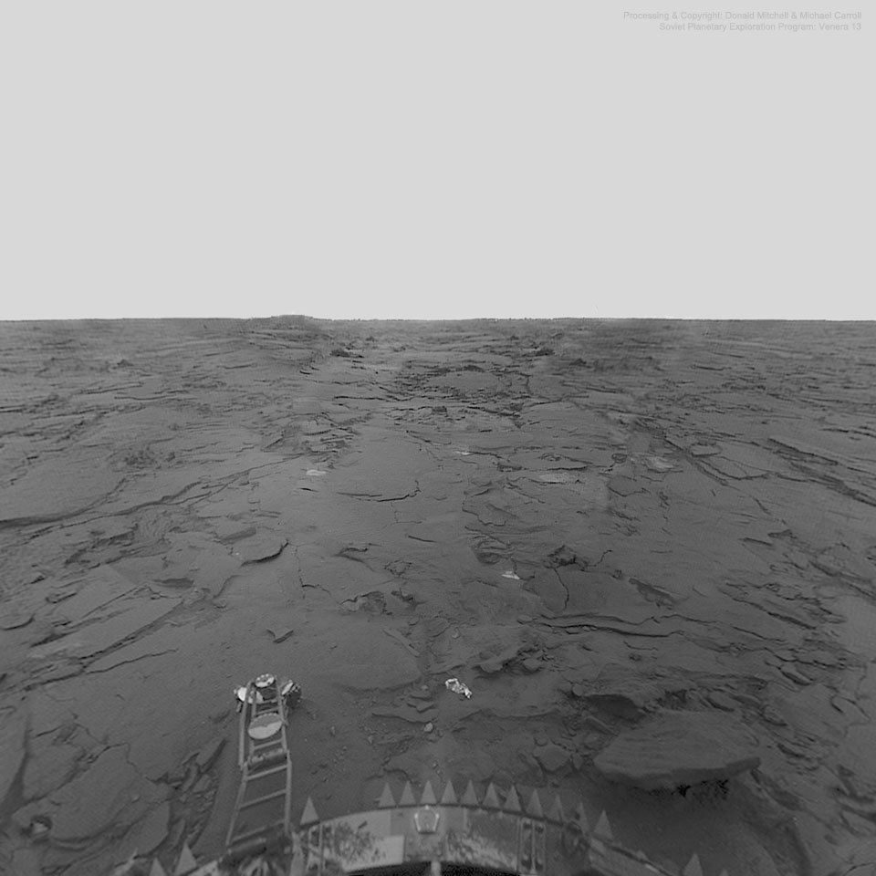 Real color photograph of Venus's rocky surface taken by the Soviet Venera 13 lander in 1982, showing flat basalt-like rock slabs before the spacecraft was destroyed by heat and pressure