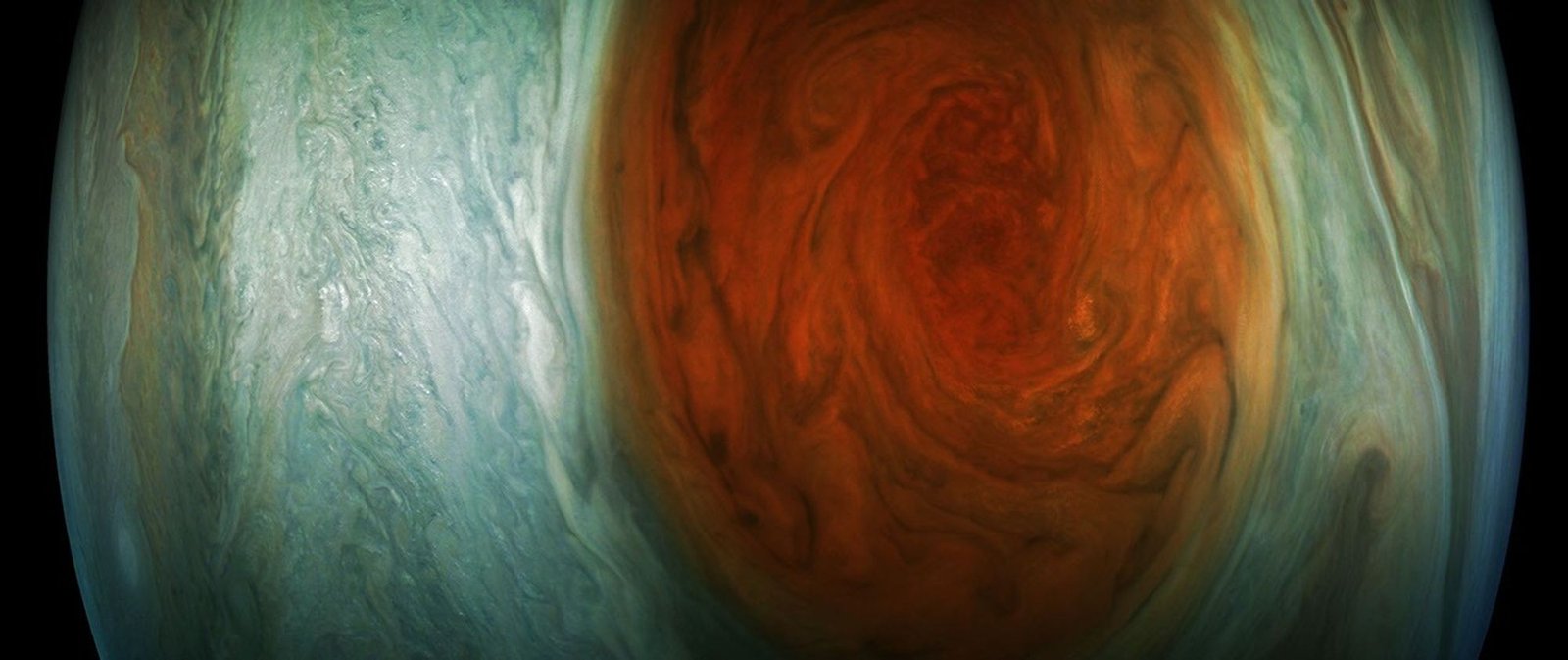 Jupiter: The Planet That Never Stopped Forming Real NASA Juno close up photograph of Jupiter's Great Red Spot and the turbulent clouds swirling around it, in enhanced color